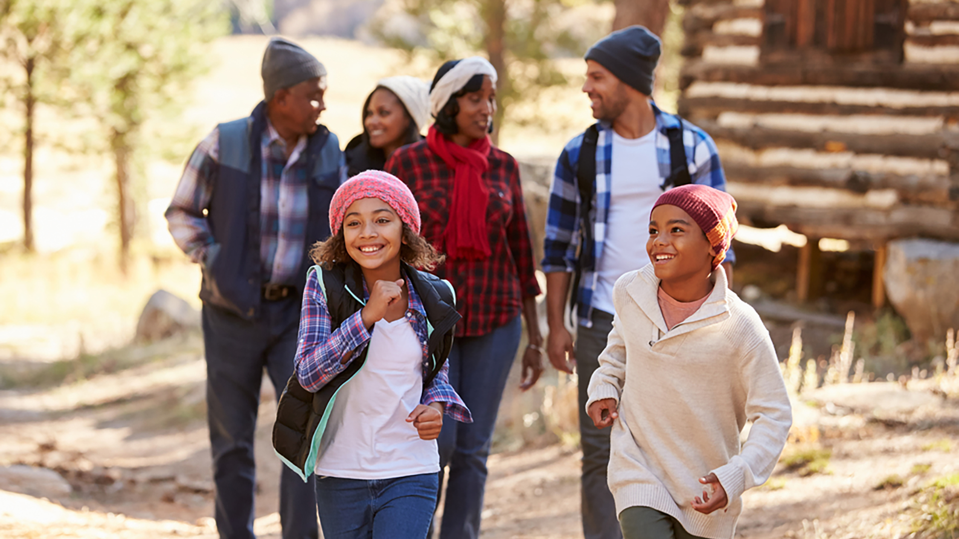 Two kids walking ahead of four other family members in the woods