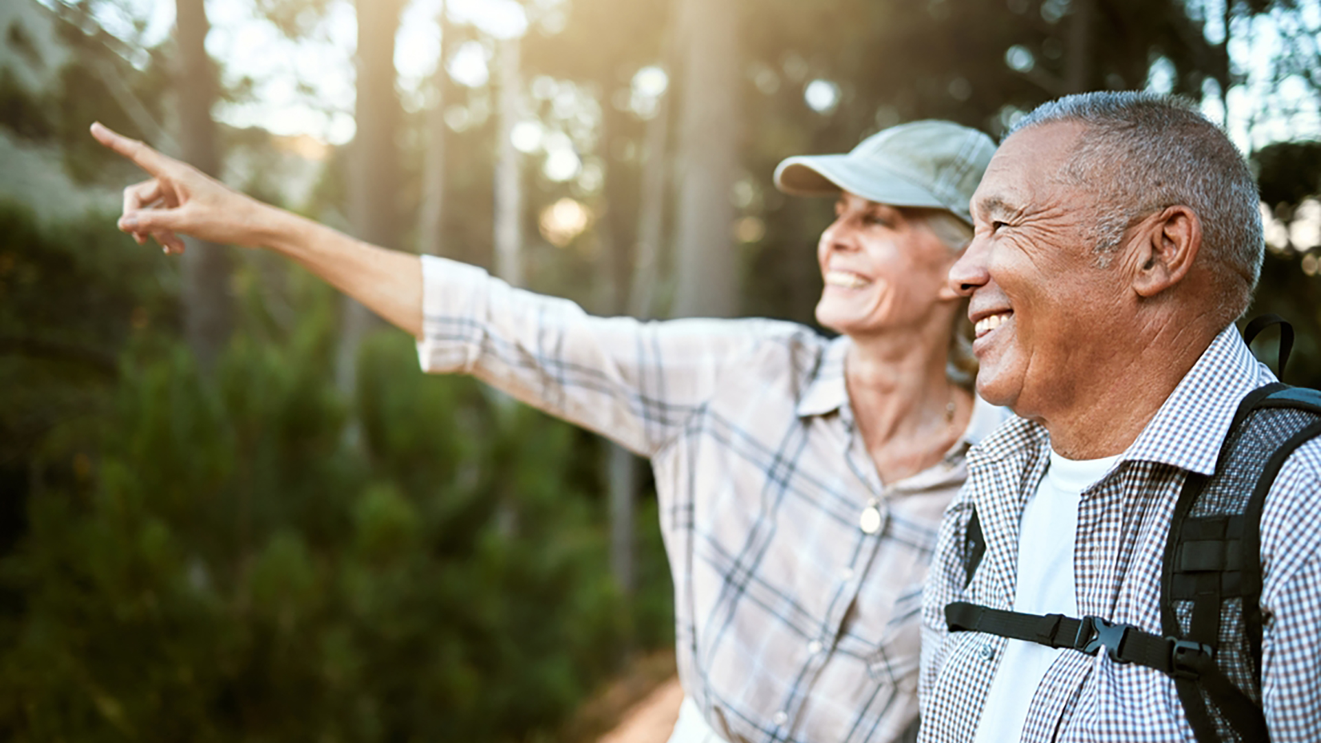 Two elderly people on a hike in the woods